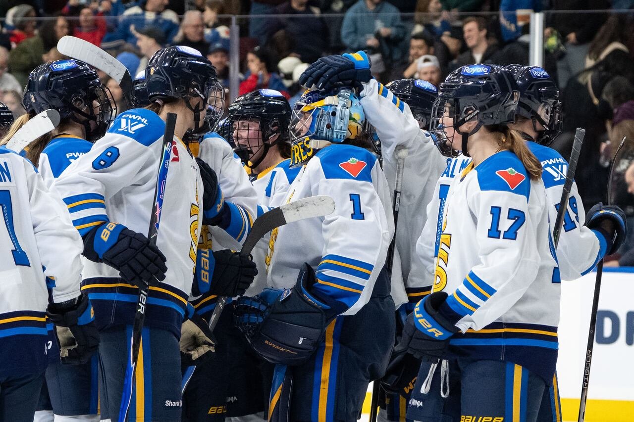 default-460 A group of women in Toronto Sceptres jerseys celebrating on the ice.