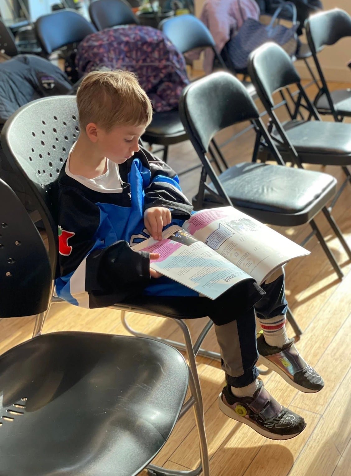default-463 A child in a Sceptres jersey engrossed in reading.