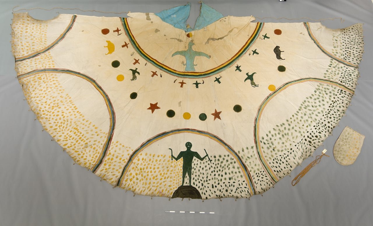 A painted teepee cover made of white hide, displayed on a grey background.